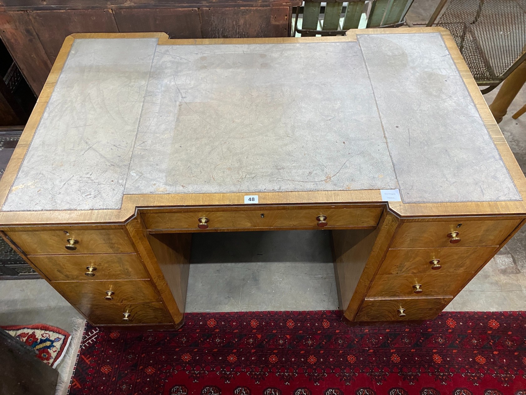 An Art Deco style walnut inverse breakfront kneehole desk, length 122cm, depth 72cm, height 76cm